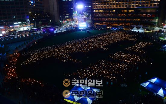 지난 17일 시청 앞 서울광장에서 열린 세월호 1주기 추모행사에서 참가자들이 4160개의 촛불로 세월호 형상을 만들고 있다. 민주주의국민행동이 주최한 이번 행사는 기네스북 등재 접수가 예정돼 있다. 국민일보 이병주 기자