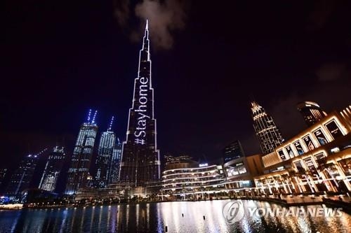 24일 아랍에미리트(UAE) 두바이의 부르즈 칼리파 빌딩에 나타난 '집에 머물자' 문구, 사진=AFP/연합뉴스