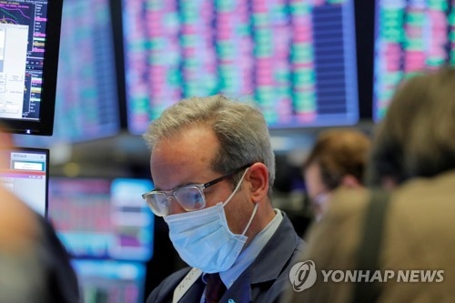 2020년 3월 20일 미국 뉴욕증권거래소(NYSE)에서 한 트레이더가 마스크를 쓴 채 업무를 보고 있다, 사진=로이터/연합뉴스